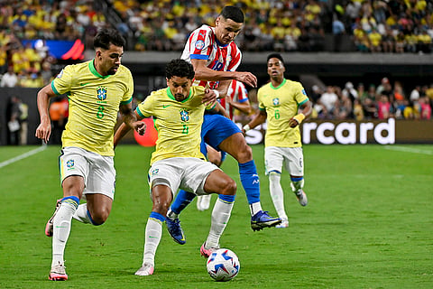 Marquinhos and Alex Arce battle for the ball
